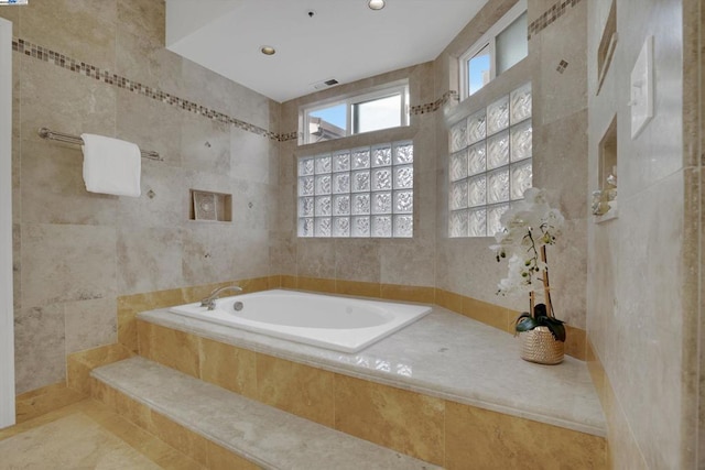 bathroom featuring tiled bath, tile walls, and tile patterned floors