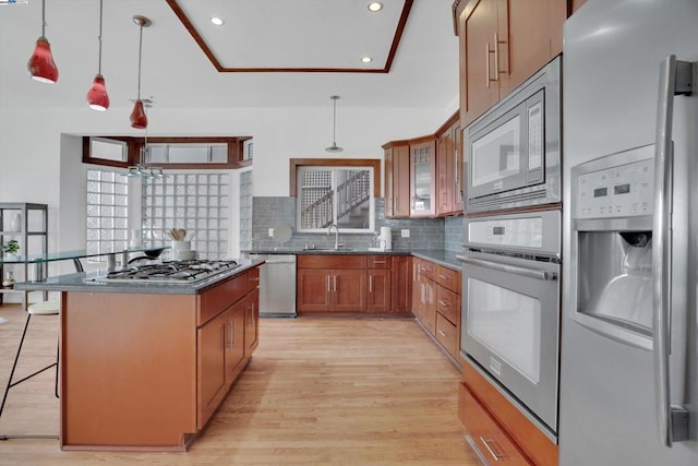 kitchen with tasteful backsplash, pendant lighting, a kitchen island, appliances with stainless steel finishes, and a breakfast bar area