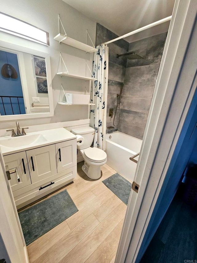 full bathroom with toilet, shower / bathtub combination with curtain, hardwood / wood-style floors, and vanity