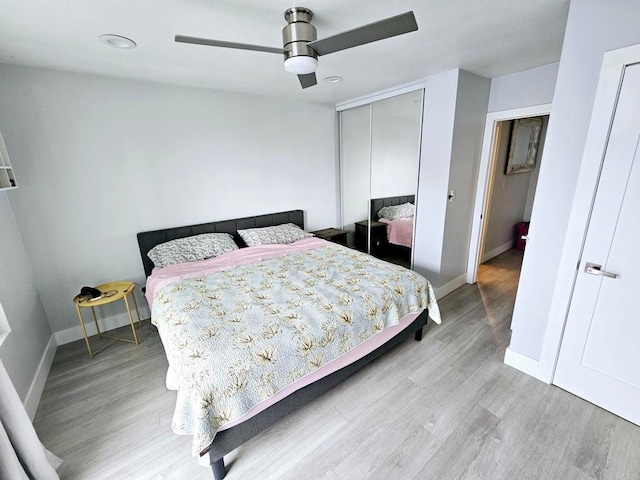 bedroom featuring ceiling fan, a closet, and light hardwood / wood-style floors