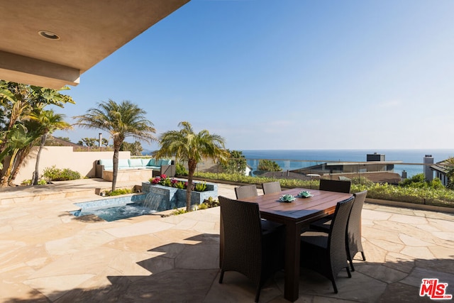 view of patio featuring pool water feature, a water view, and a fenced in pool