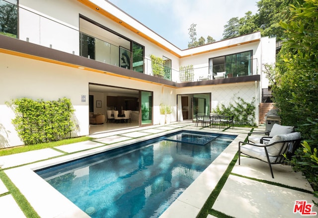 rear view of property with a balcony and a patio