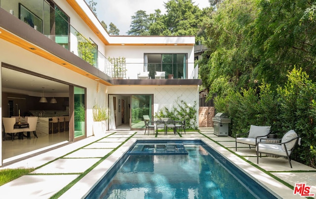 rear view of house featuring a patio area and a balcony