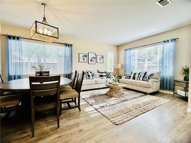 living room with an inviting chandelier and light wood-type flooring