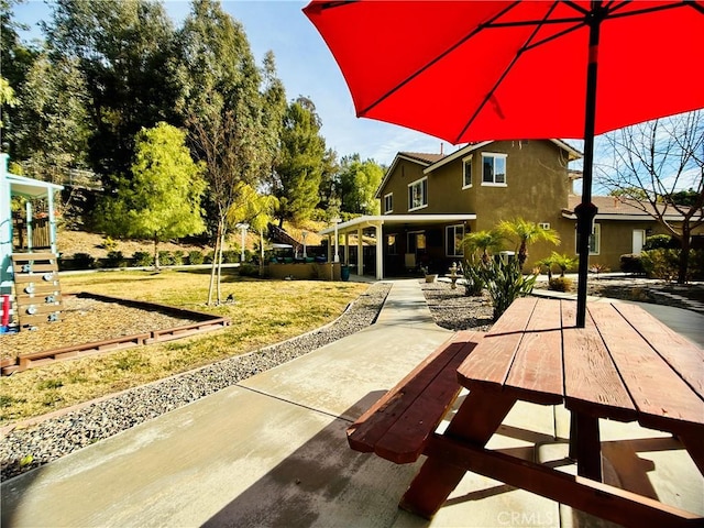 view of community with a patio and a lawn