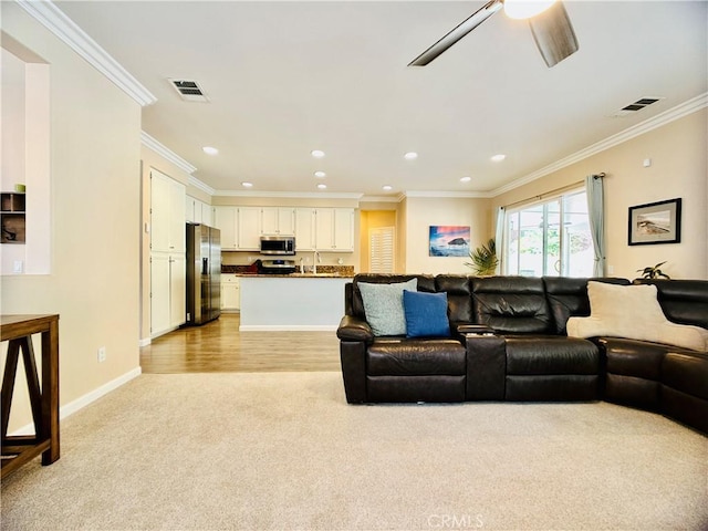 carpeted living room featuring ornamental molding and ceiling fan