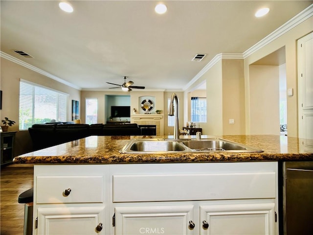 kitchen featuring crown molding, dark stone counters, sink, and white cabinets