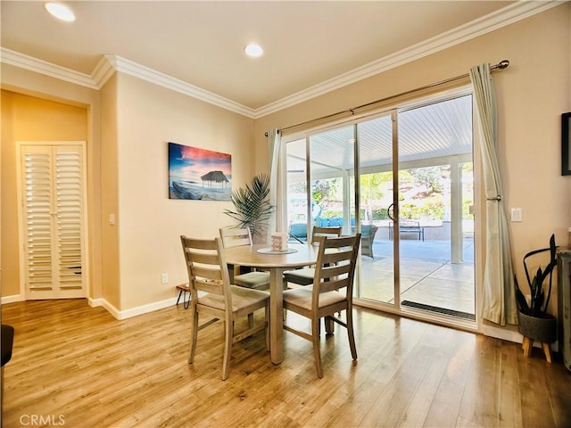 dining space featuring crown molding and light hardwood / wood-style flooring