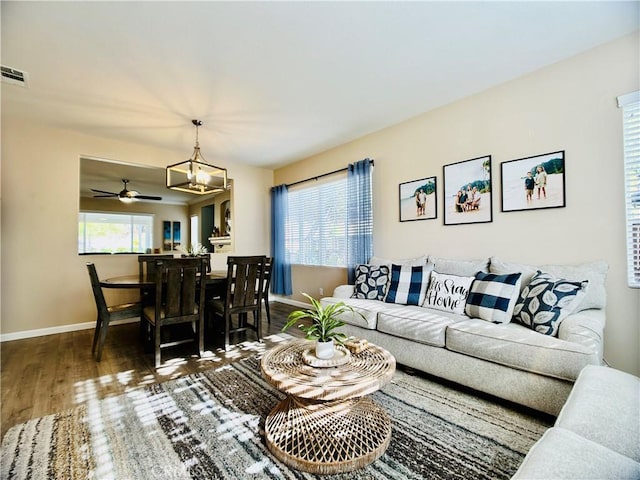 living room featuring hardwood / wood-style flooring and ceiling fan with notable chandelier