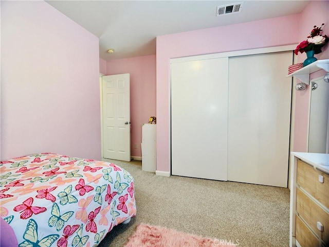 bedroom featuring light colored carpet and a closet