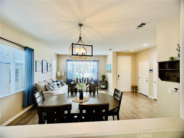 dining area with hardwood / wood-style flooring and a notable chandelier