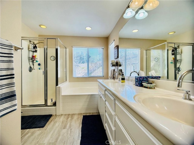 bathroom featuring shower with separate bathtub, hardwood / wood-style floors, and vanity