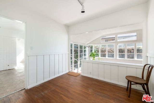 interior space with track lighting and vaulted ceiling