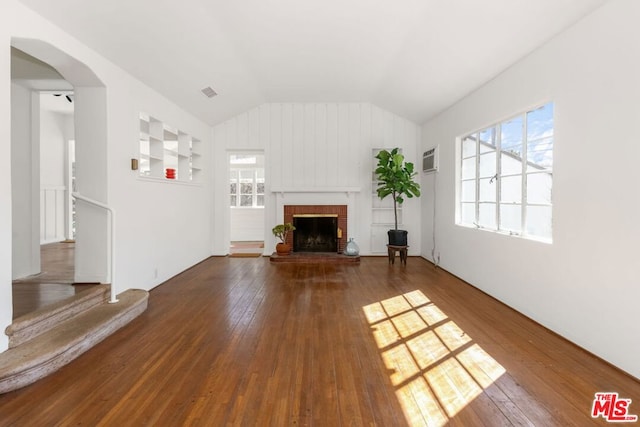 unfurnished living room featuring a fireplace, dark hardwood / wood-style flooring, and a wall mounted AC