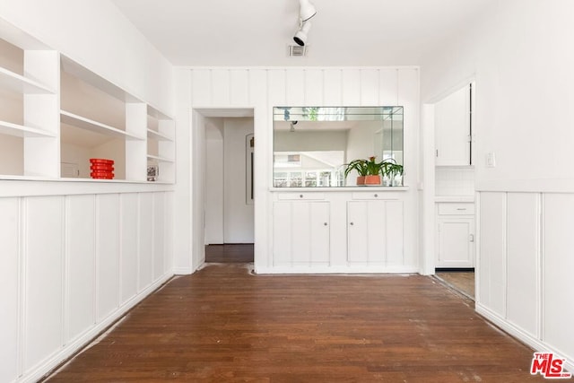 hall with built in shelves and dark hardwood / wood-style floors