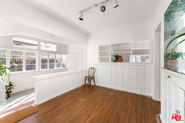 unfurnished room featuring track lighting and dark hardwood / wood-style floors