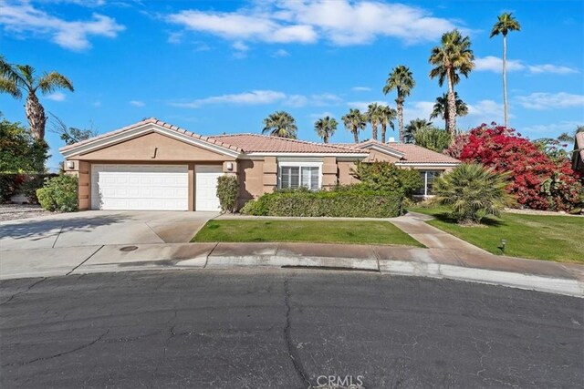 ranch-style home featuring a front lawn and a garage