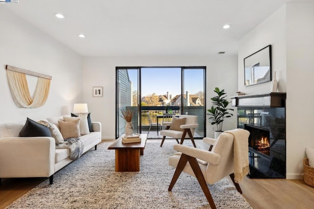 sitting room with a high end fireplace and wood-type flooring