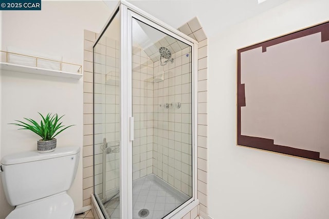 bathroom featuring toilet and a shower with shower door