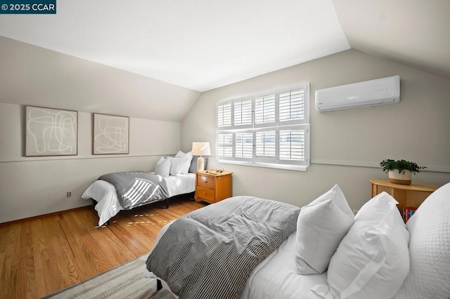 bedroom with lofted ceiling, an AC wall unit, and wood-type flooring