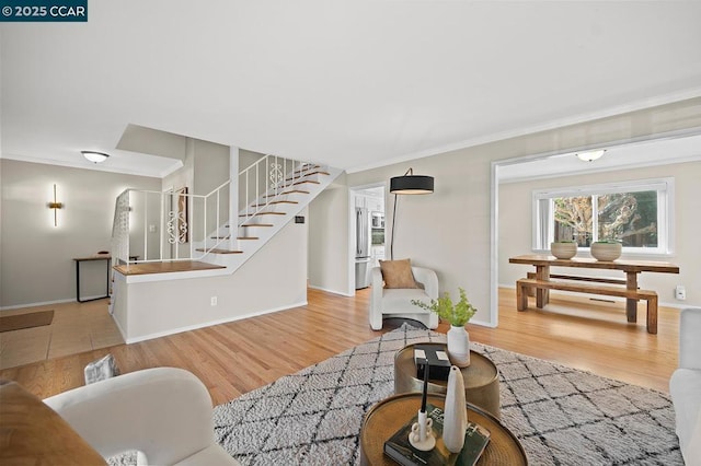 living room with crown molding and light hardwood / wood-style flooring