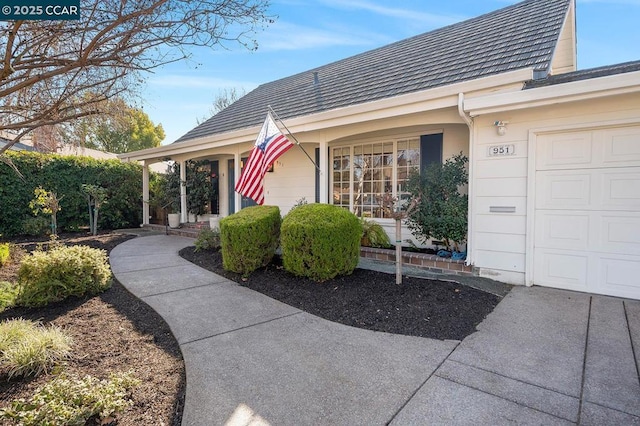 doorway to property featuring a garage and a porch