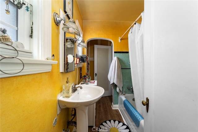 bathroom with hardwood / wood-style flooring, sink, and shower / tub combo with curtain