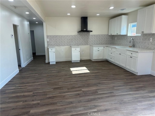 kitchen with sink, white cabinets, dark hardwood / wood-style flooring, and wall chimney exhaust hood