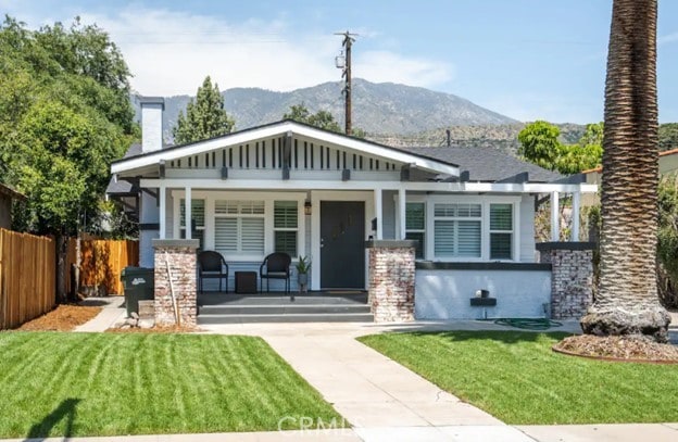 craftsman inspired home featuring a mountain view, a front lawn, and a porch