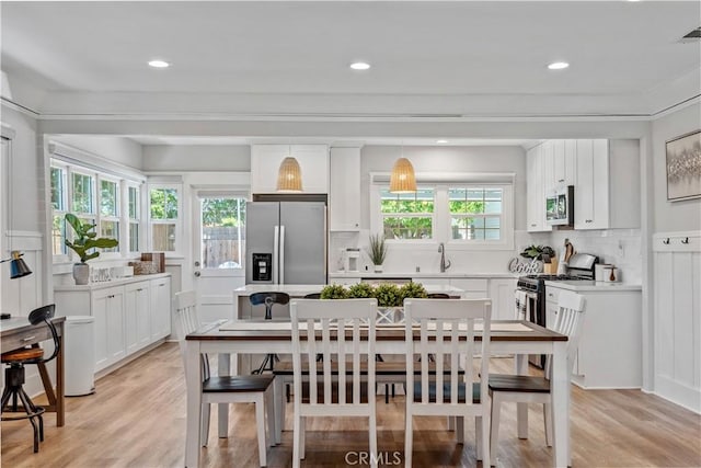 dining area with plenty of natural light and light hardwood / wood-style flooring