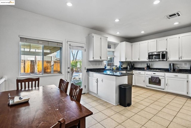 kitchen featuring sink, white cabinets, light tile patterned floors, and stainless steel appliances