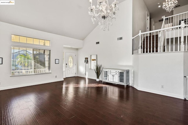 unfurnished living room with high vaulted ceiling, hardwood / wood-style floors, and a chandelier