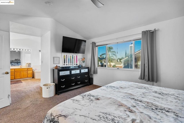 bedroom with vaulted ceiling, connected bathroom, and dark colored carpet