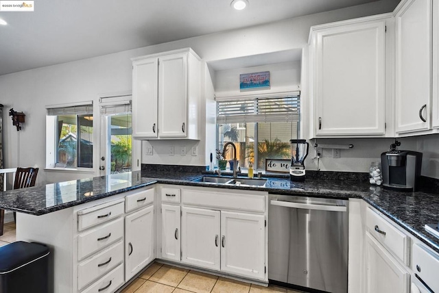 kitchen with white cabinets, dishwasher, dark stone countertops, sink, and light tile patterned flooring