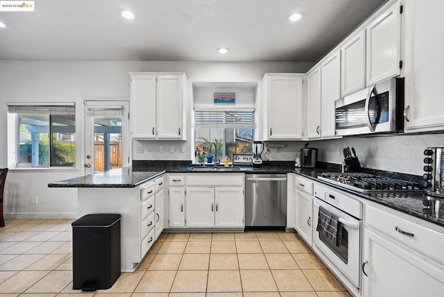 kitchen with white cabinetry, light tile patterned floors, and stainless steel appliances