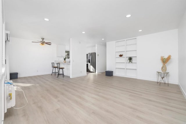 unfurnished living room with built in features, light hardwood / wood-style floors, and ceiling fan