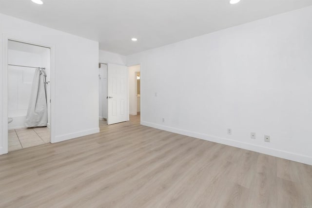 unfurnished bedroom featuring light hardwood / wood-style flooring, a closet, and ensuite bathroom