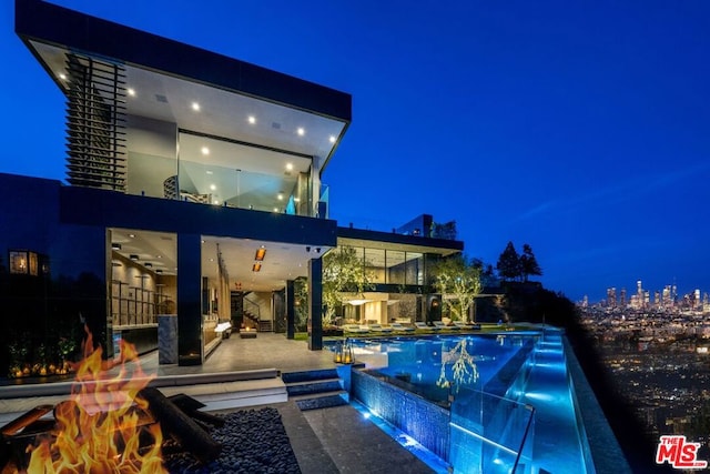 pool at night with a patio area