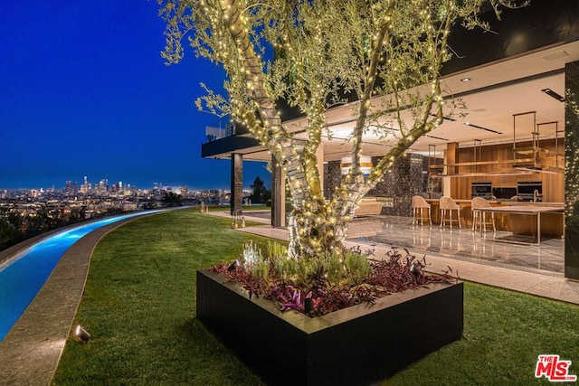 yard at night featuring a patio area