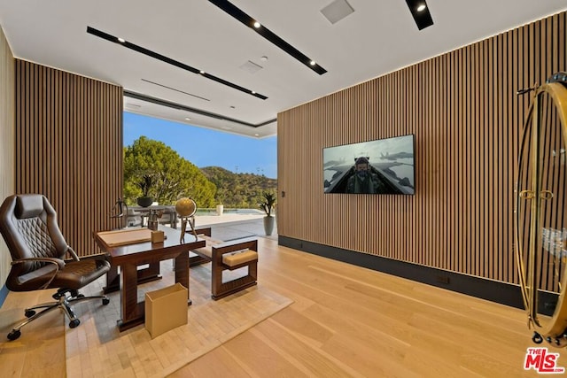 interior space with expansive windows, wood walls, and light hardwood / wood-style floors