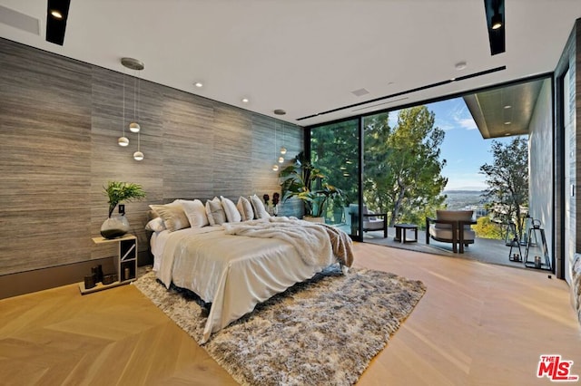 bedroom with parquet flooring and expansive windows