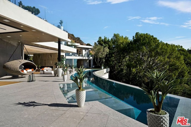 view of swimming pool with an outdoor living space and a patio