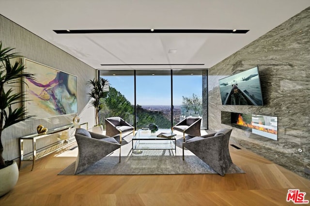 sitting room with expansive windows, a fireplace, and hardwood / wood-style floors