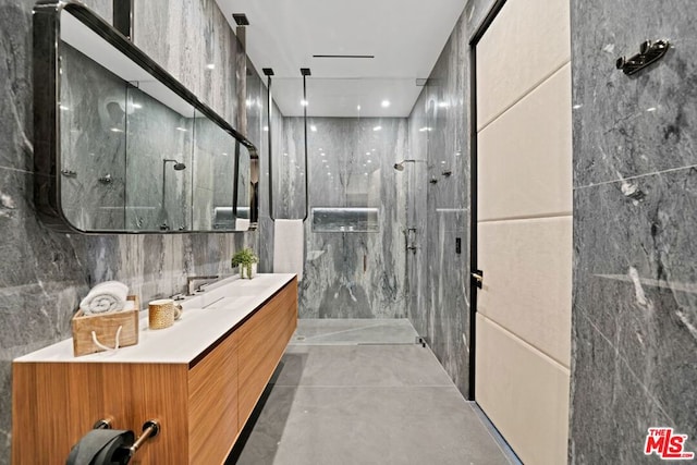 bathroom with vanity, tile walls, and a shower