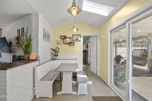 dining room featuring vaulted ceiling with skylight