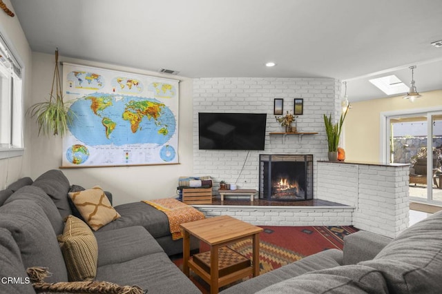 living room with a skylight and a fireplace