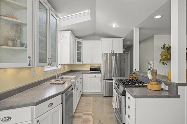 kitchen featuring sink, white cabinetry, lofted ceiling with skylight, and stainless steel appliances