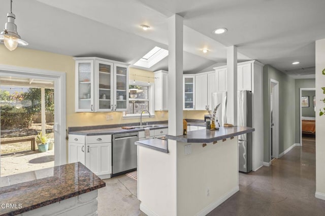 kitchen with vaulted ceiling with skylight, a center island, white cabinetry, sink, and stainless steel dishwasher