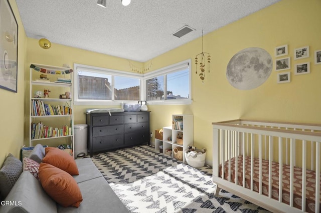 bedroom featuring a textured ceiling and a crib