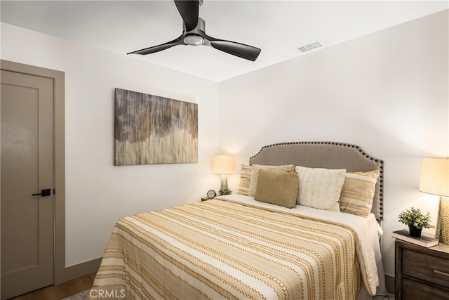 bedroom with visible vents, a ceiling fan, and wood finished floors